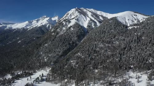 Air Flight Through Mountain Clouds Over Beautiful Snowcapped Peaks of Mountains and Glaciers