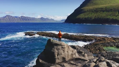 Aerial View of Drone Flying Around a Manover Rock Beachman Resting in Front of Landscape