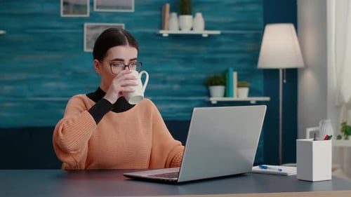 Junge Erwachsene surfen auf Laptop im Internet, um Remote-Schularbeiten zu erledigen