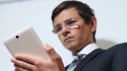 Young Adult Uses Tablet in Business Setting