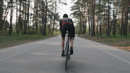 Starker Radfahrer, der Fahrrad aus dem Sattel fährt.