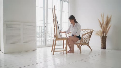 Woman Painting on Canvas in Bright Studio