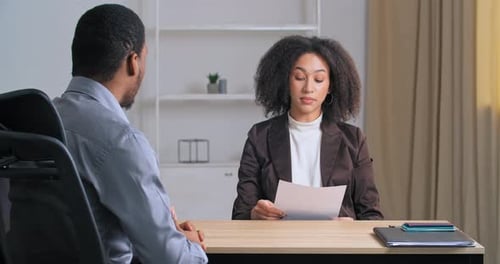Unrecognizable Afro American Businessman Sits in Office at Table Talking to Managers Female