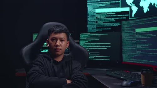 Asian Boy Hacker Hacking With Multiple Computer Screens And Pose In Dark Room