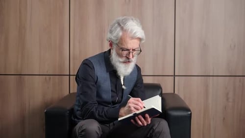 Elegant Grayhaired Man Designer Works in the Office Art Director Writes Down Ideas and Concepts in a