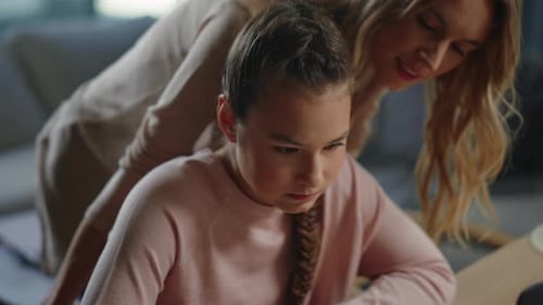 Woman Helping Teen Girl with Homework at Home