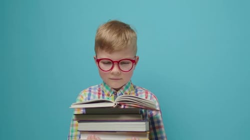 Child Reads Stack of Books Wearing Red Glasses