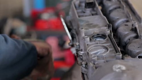 Close-up of the Mechanic's Hands in Gloves, He Repairs the Engine in the Car.