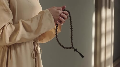 Hands Holding Rosary Beads in Prayer