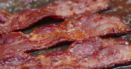 Bacon Sizzling in Frying Pan Close Up