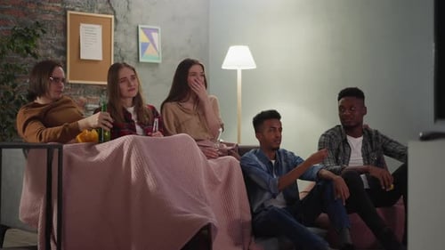 Friends Watching Television Together Indoors on the Couch