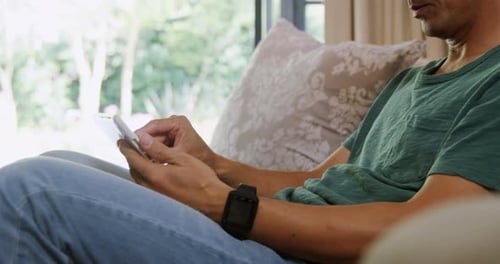 Man Using Tablet on Couch Indoors Daytime