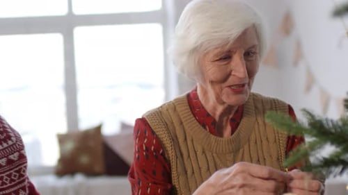 Senior Couple Decorating Christmas Tree with Ornaments