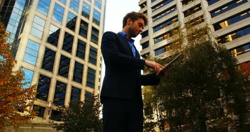Man in Suit Using Tablet in City Autumn Setting