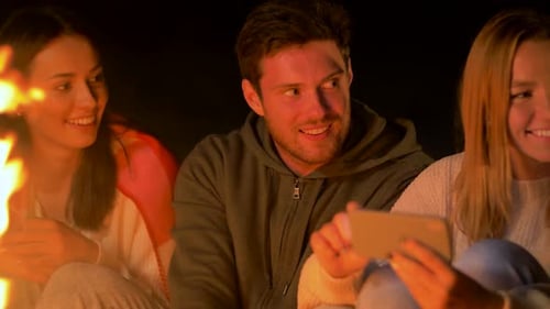 Friends Gather Around Campfire at Night