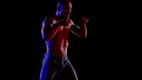 Muscular Man Boxing in Red and Blue Light