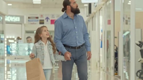 Loving Father Walking at Shopping Mall with His Adorable Little Daughter