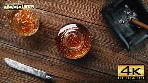 Whiskey close up in glass with ice on wood