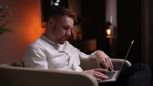 Young Adult Typing on Laptop at Home, Night