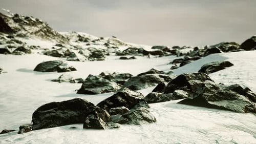 Verschneite Berge und dunkle Felsen