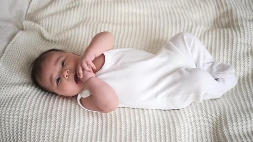 Infant Lying on White Knitted Blanket at Home