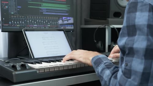 Hands playing on electric midi keyboard piano at home music recording studio. Music concept