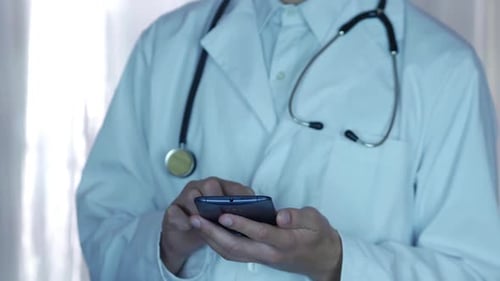 Doctor Using Smartphone in Hospital Setting