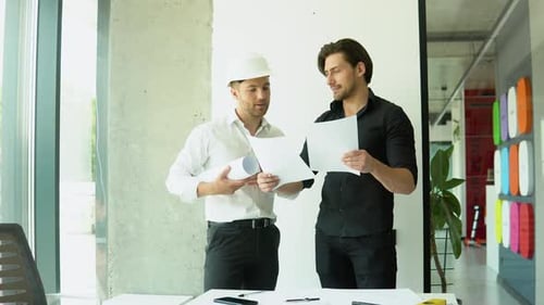 Two Architect Discussing Help Create Plan with Blueprint Home Building at Office