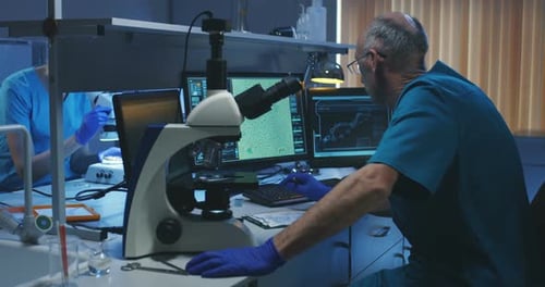 Biologist Analyzing Sample with Microscope