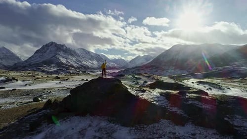 Lonely mountaineer get rest on snowy mountain high above the clouds into the sun, Mountaineer reache