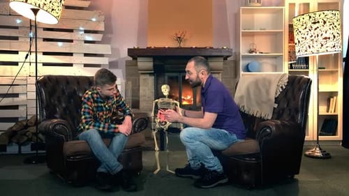 Father Explaining His Elder Son the Bone Structure of Human Body Showing on Skeleton