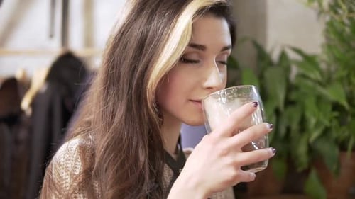 Beautiful Girl Drinking Cacao or Coffee in Cafe