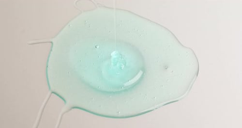 Light Blue Liquid Pouring onto a White Surface