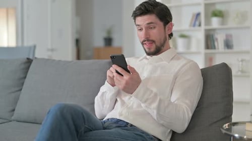 Excited Man Celebrating Success Using Mobile Phone