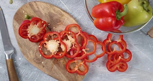 Fresh Colorful Bell Peppers Sliced on Cutting Board