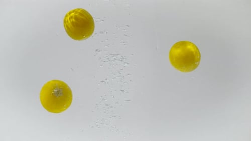 Three Small Yellow Fruits Floating in Water
