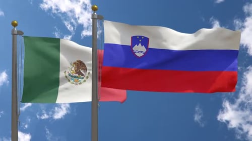 Mexico and Slovenia National Flags Waving Against Blue Sky