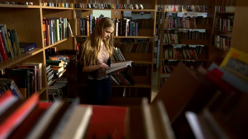 A Portrait of Girl Student Reading a Book in the Library
