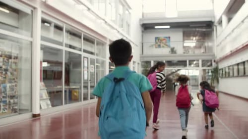 Medium Shot of Boy Walking in School Behind His Classmates