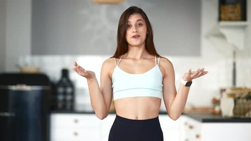 Young Woman Talking About Fitness in Her Kitchen