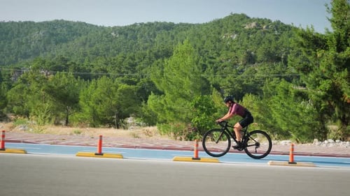 Woman Cyclist Riding Bike on Tropical Path
