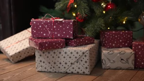 De magnifiques coffrets cadeaux de Noël dans une pile de cadeaux se trouvent sur le plancher en bois sous le sapin