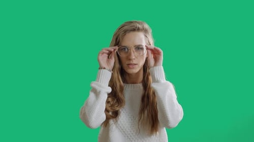 Woman Takes off Glasses in Front of Green Screen