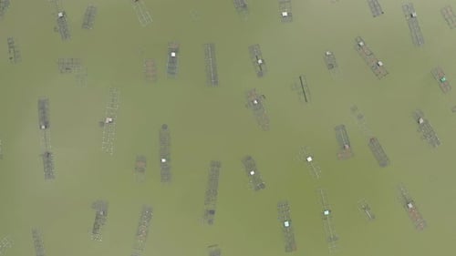 Aerial view of local fishing trap net in canel with fisherman home, lake or river at sunset. Nature