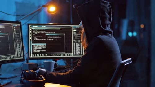 Person Coding at Computer in Dark Room