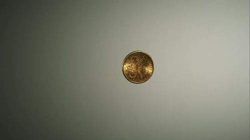 Golden coin flipping in the air in ultra slow motion