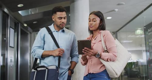 Professionals Discussing Business on Tablet in Modern Office