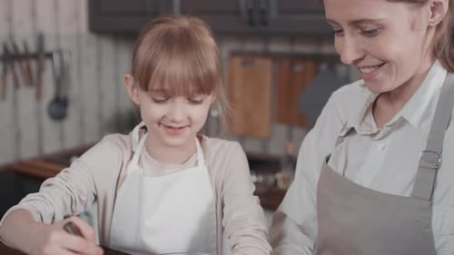 Mother and Child Cooking Together in Kitchen