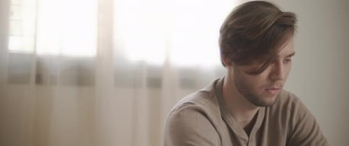 A young man working from home, in his bedroom. Close up, slow motion