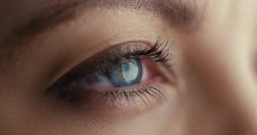 Nahaufnahme einer Frau, die blaue Augen öffnet